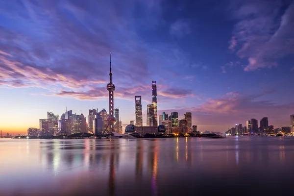 Waterfront cityscape and illuminated skyline at dawn — Stock Photo, Image