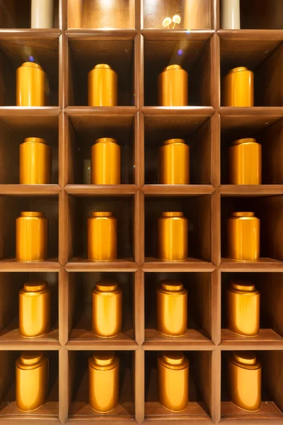 Golden tea cans in cupboard — Stock Photo, Image