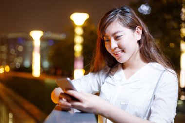 Asyalı kız cep telefonuyla geceleri