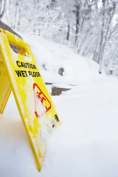 Warning caution sign board on snow floor — Stock Photo, Image