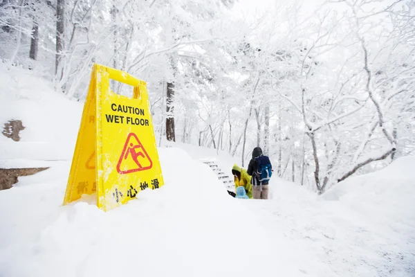 Ostrzeżenie przestroga znak pokładzie na śniegu — Zdjęcie stockowe
