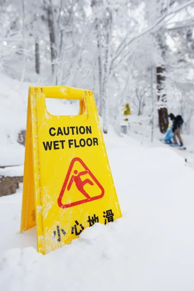Попереджувальний знак обережності на сніговій підлозі — стокове фото