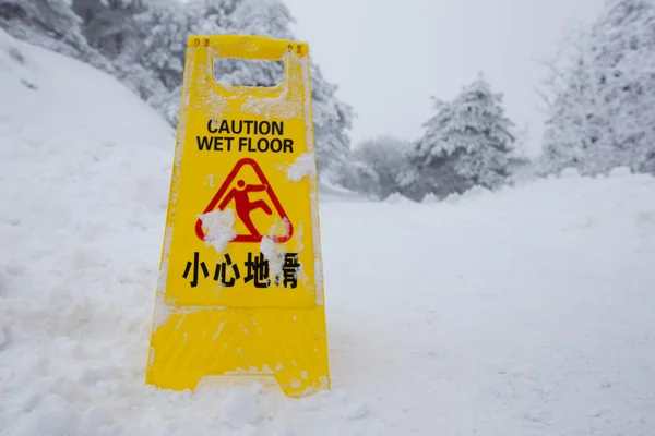 Предупреждающая табличка на снежном полу — стоковое фото
