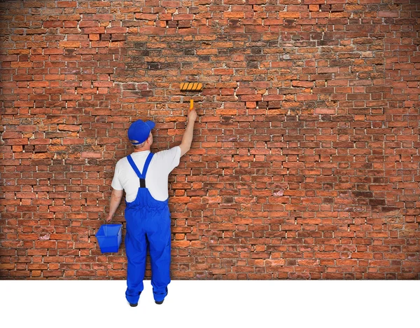 House painter paints brick wall — Stock Photo, Image