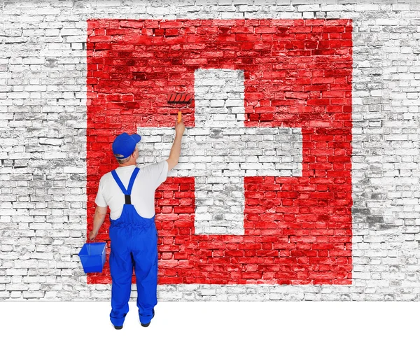 Malarz obejmuje ściany z flaga Szwajcarii — Zdjęcie stockowe