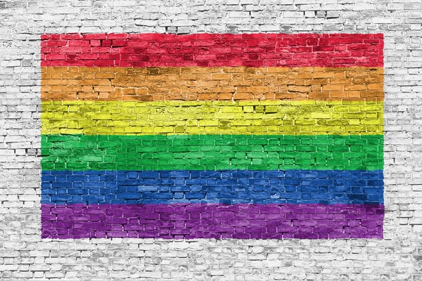 Bandeira do arco-íris pintada sobre parede de tijolo — Fotografia de Stock