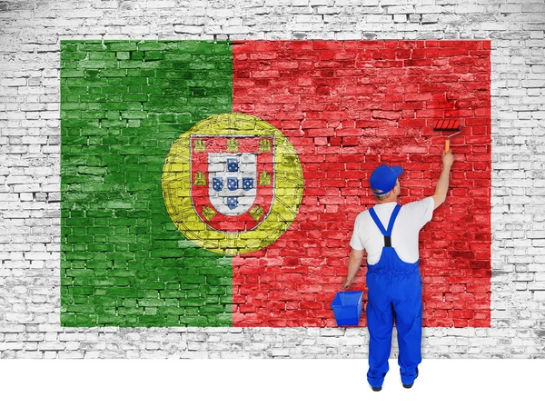 House painter covers brick wall with flag of Portugal — Stock Photo, Image