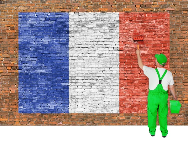 House painter covers brick wall with flag of France — Stock Photo, Image