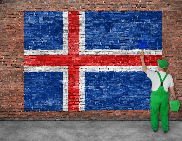 Casa pintor pinta la bandera de Islandia en la pared de ladrillo viejo — Foto de Stock