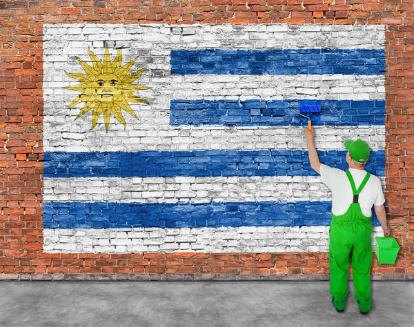 Malíř maluje vlajka Uruguaye — Stock fotografie