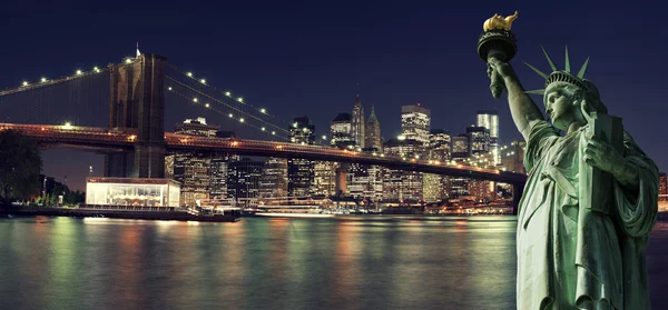 Ορίζοντα της Νέας Υόρκης το βράδυ με το άγαλμα της ελευθερίας — Φωτογραφία Αρχείου