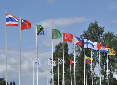 Mavi gökyüzü üzerinde farklı ülkelerin bayrakları