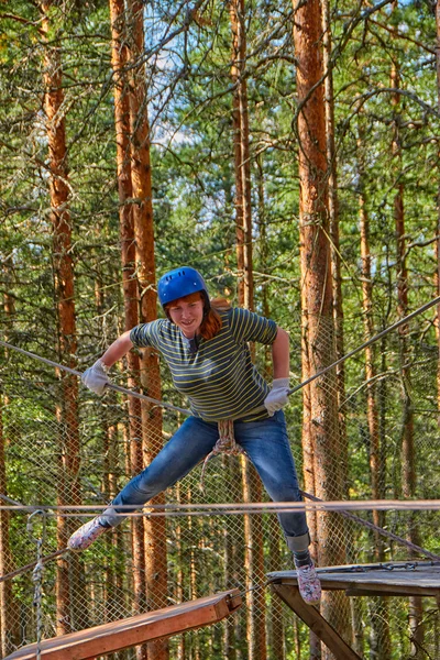 Chica en un desafío de parque de cuerdas de bosque —  Fotos de Stock