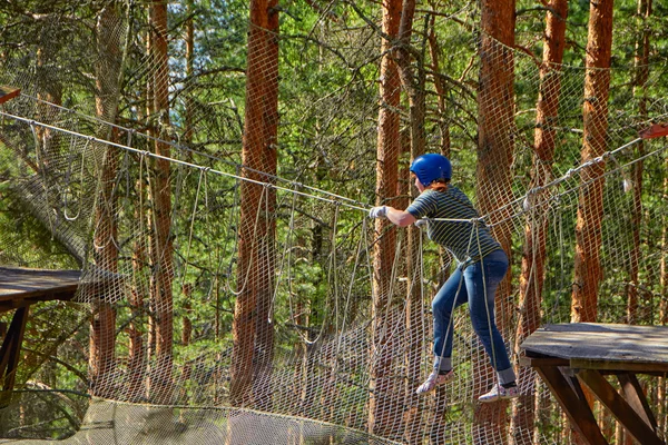 Chica en un desafío de parque de cuerdas de bosque —  Fotos de Stock