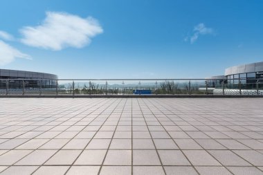 Güneşli gökyüzüne karşı boş tuğla zemini olan modern şehir manzarası