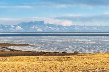 Alacakaranlıktaki Namtso gölü manzarası, Tibet 'teki kutsal göl ve kar dağı