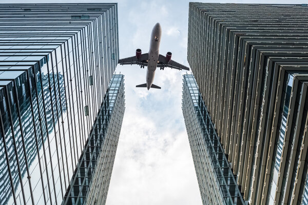 Modern glass office building with airplane , abstract business backgroun