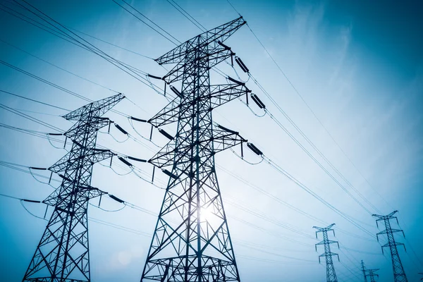 High voltage electricity transmission pylon silhouetted — Stock Photo, Image