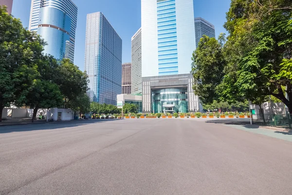 Asphalt pavement with modern urban background — Stock Photo, Image