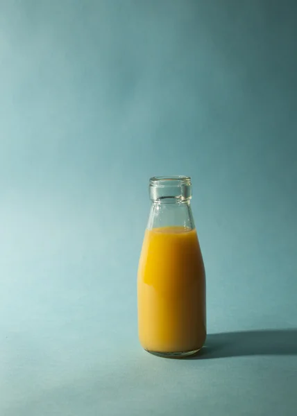 Vaso de zumo de naranja sobre fondo verde azulado — Foto de Stock