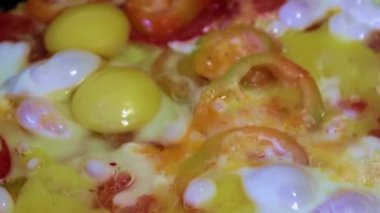 Kahvaltı için çırpılmış yumurta ve taze sebze pişirmek.