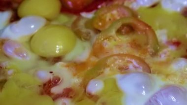 Kahvaltı için çırpılmış yumurta ve taze sebze pişirmek.