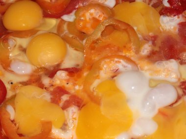 Kızarmış yumurtayı taze biberle pişirme işlemi.