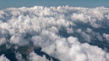 Uzay aracının penceresinden bulutlu gökyüzünün görüntüsü