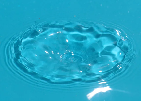 液体が落下したときの衝撃後のきれいな水の表面 — ストック写真
