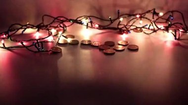 Bir yığın altın sikke ve Noel çelengi ışığı.