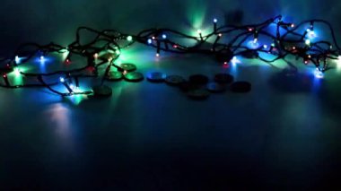 Bir yığın altın sikke ve Noel çelengi ışığı.