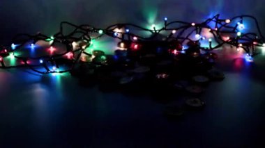 Bir yığın altın sikke ve Noel çelengi ışığı.