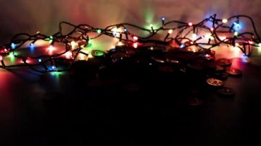 Bir yığın altın sikke ve Noel çelengi ışığı.