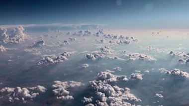 Bir uçak penceresinden dışarı bakarken yerin üstünde kümülüs bulutları