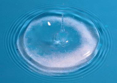 Düşen temiz su damlası ve sıvının yüzeyine çarpan bir şok.