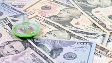 İstikrarlı para biriminin sembolü olarak Amerikan kağıt yığınının üzerinde dönen plastik bir girdap dolar faturaları