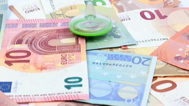 通貨安定の象徴としてのユーロ紙幣の山の上でのプラスチック製の回転は — ストック動画