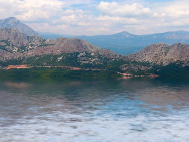 Akdeniz 'in dalgalarındaki dağ manzarasının yansıması.