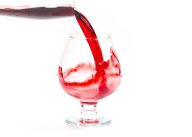 Bir bardağa dökerken kırmızı şarap bukleleri ve damlaları