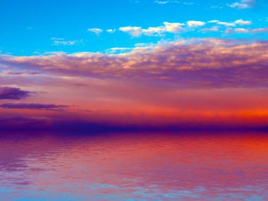 Deniz boşluğunun sakin yüzeyinde mavi bulutlu gökyüzünün yansıması