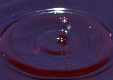 Suyun yüzeyine bir sıvı damlası düşer ve çok renkli desenler yaratır.