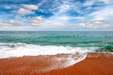 Deniz dalgaları ve kumlu plaj açık hava aktivitelerinin bir unsuru.