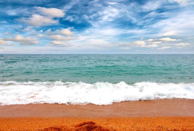 Deniz dalgaları ve kumlu plaj açık hava aktivitelerinin bir unsuru.