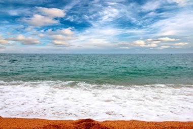 Deniz dalgaları ve kumlu plaj açık hava aktivitelerinin bir unsuru.