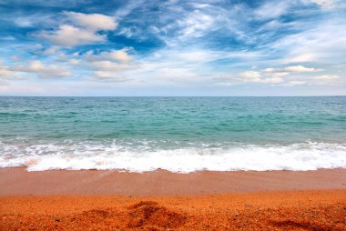 Deniz dalgaları ve kumlu plaj açık hava aktivitelerinin bir unsuru.