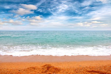 Deniz dalgaları ve kumlu plaj açık hava aktivitelerinin bir unsuru.