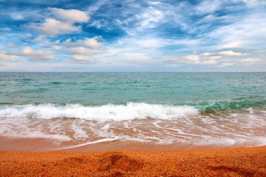 Deniz dalgaları ve kumlu plaj açık hava aktivitelerinin bir unsuru.