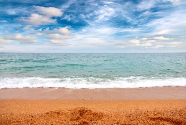 Deniz dalgaları ve kumlu plaj açık hava aktivitelerinin bir unsuru.