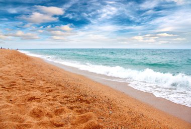 Deniz dalgaları ve kumlu plaj açık hava aktivitelerinin bir unsuru.