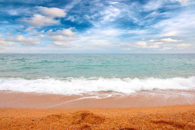 Deniz dalgaları ve kumlu plaj açık hava aktivitelerinin bir unsuru.